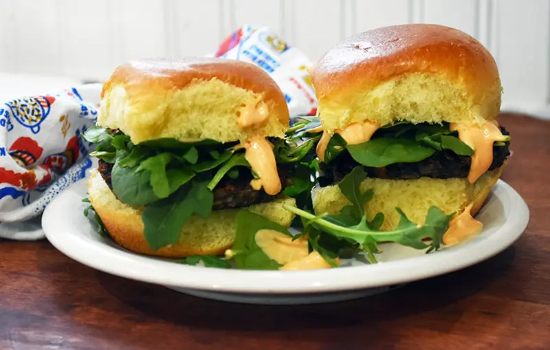 finished veggie burgers served with greens and chipotle mayo