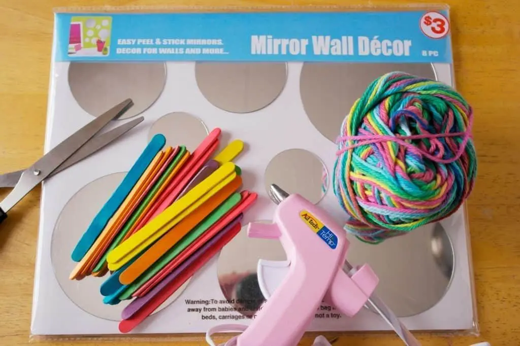 this God's Eye craft is an update on the classic craft featuring popsicle sticks and string. We added a mirror and hung them in multiples for fun decor!