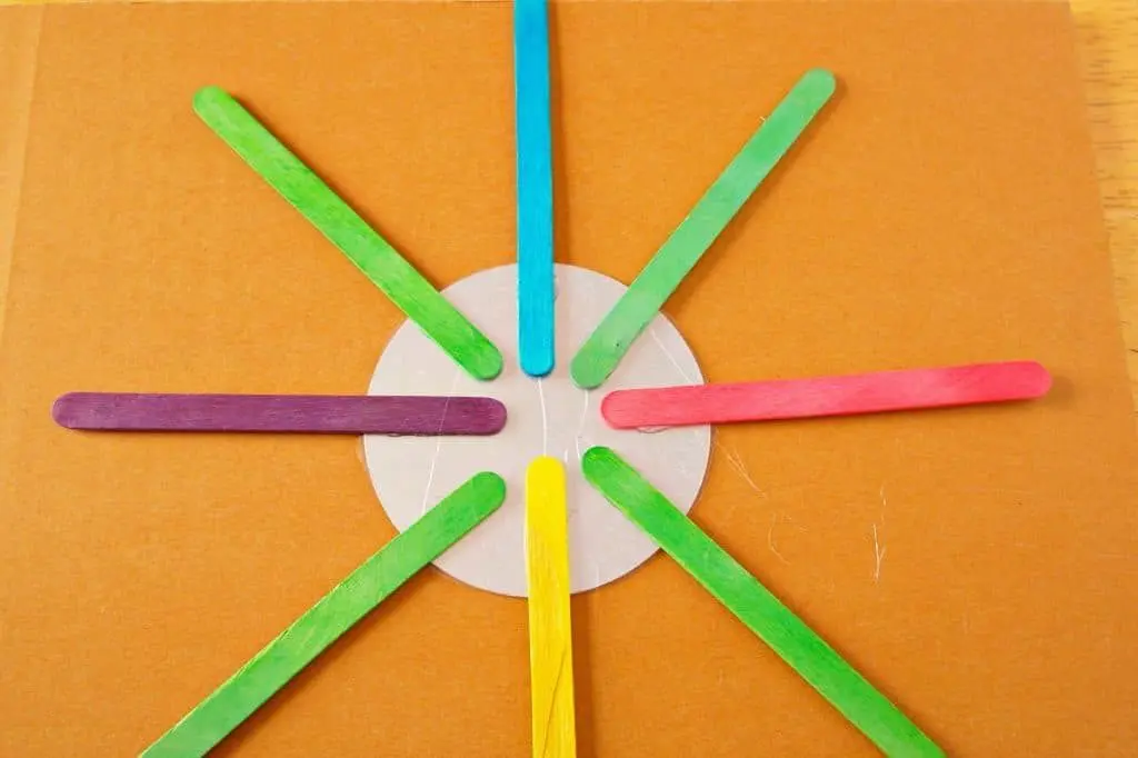 this God's Eye craft is an update on the classic craft featuring popsicle sticks and string. We added a mirror and hung them in multiples for fun decor!