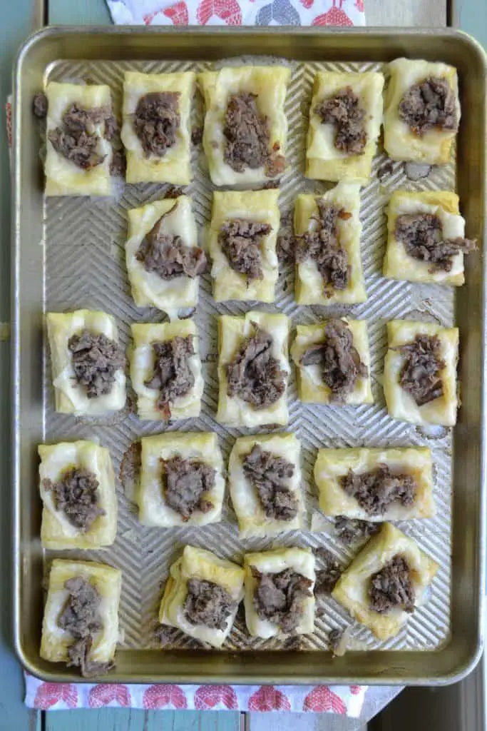 These little Philly Cheese Steak puffs are an easy, delicious appetizer with fresh veggies, flavorful beef, and buttery puff pastry. Easy, fast, and tasty!