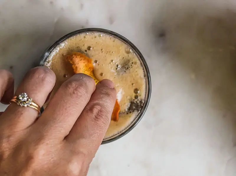 Add a bit of orange slice to the root beer cocktail.