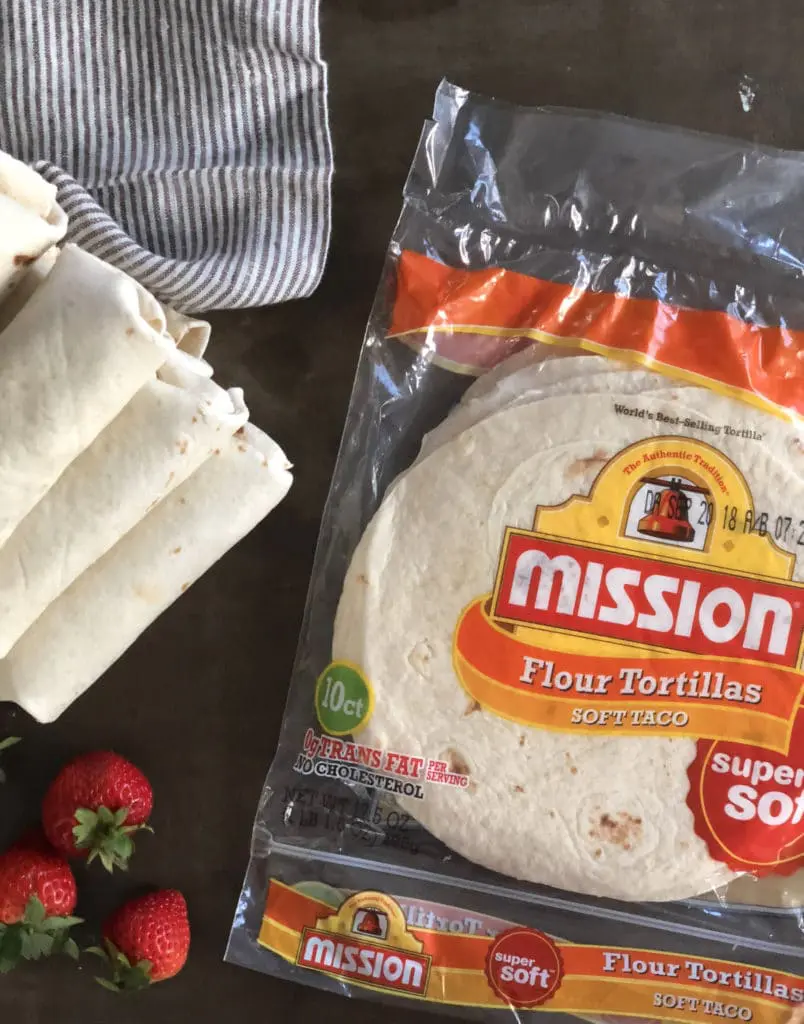 an easy dessert burrito stuffed with fresh strawberry and cream cheese