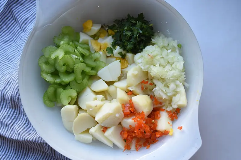 deviled egg potato salad ingredients of celery, boiled egg, pimento, red potatoes, fresh parsley, salt and pepper