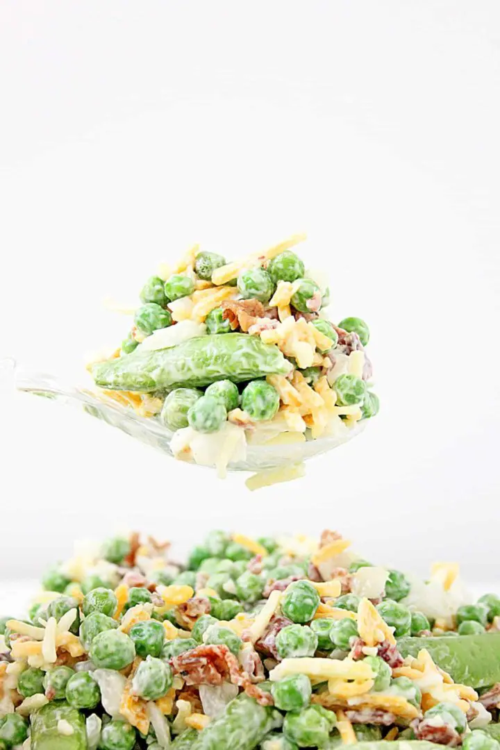 A spoonful of green pea salad with bacon and cheese