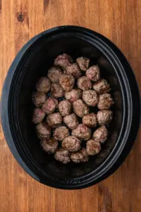 meatballs lined up in the bottom of a crock pot