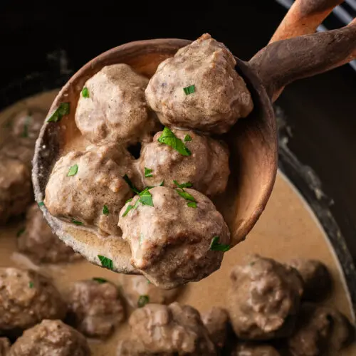a ladle scooping swedish meatballs from the crockpot