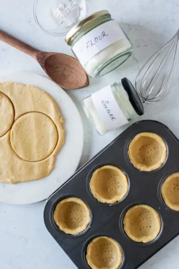 cookie cups being pressed into tins