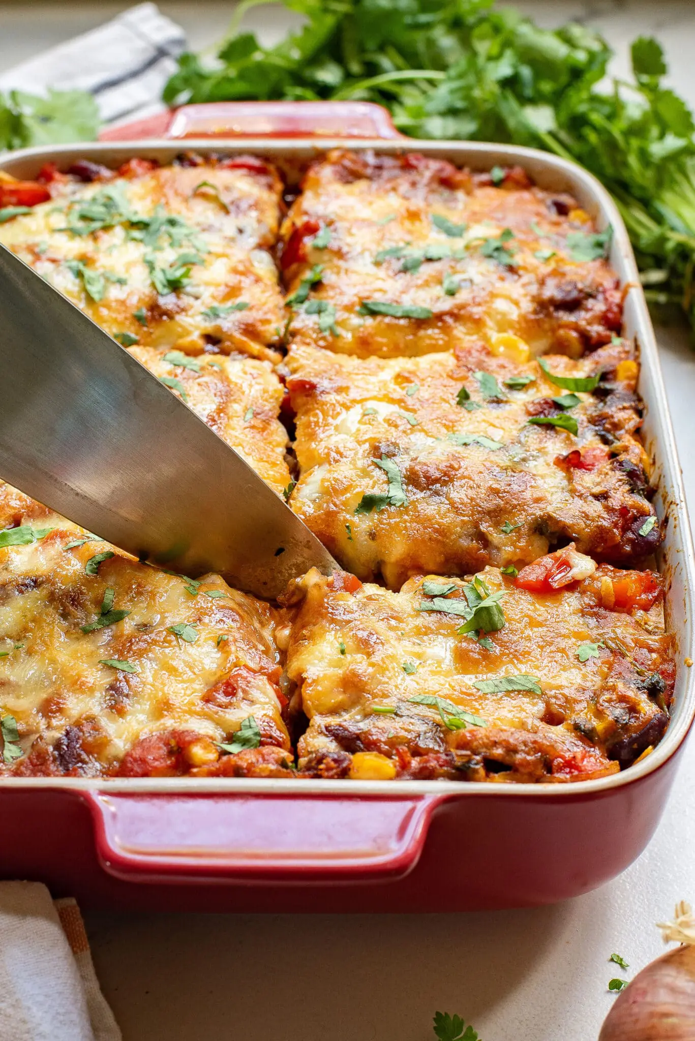 cutting into a mexican tortilla casserole