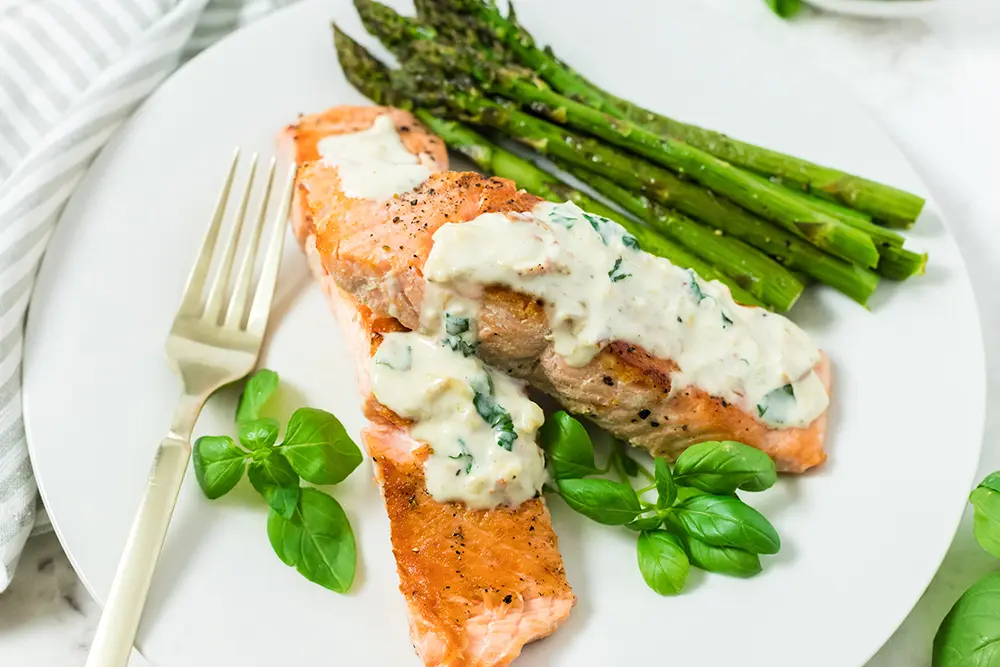 Pan roasted salmon on a plate with creamy garlic sauce