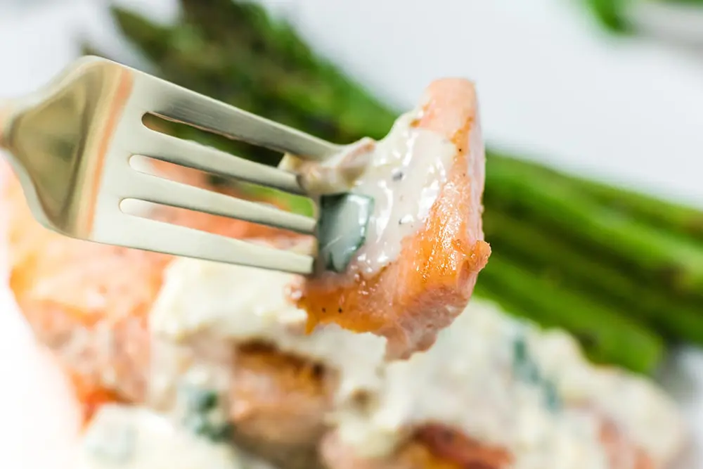 A forkful of tender salmon with garlic sauce