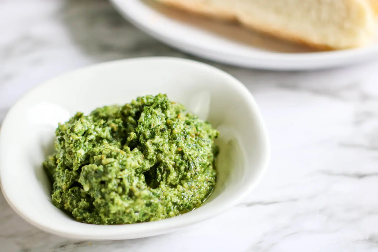 A bowl full of fresh basil pesto.