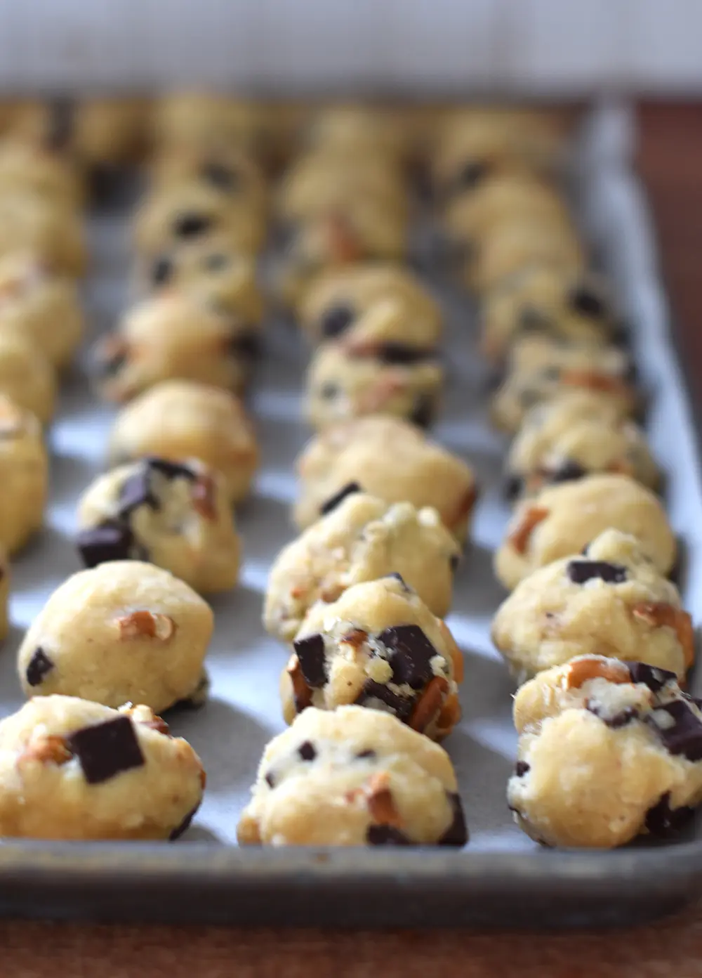 A pan full of cookie balls ready to go into the air fryer to bake.