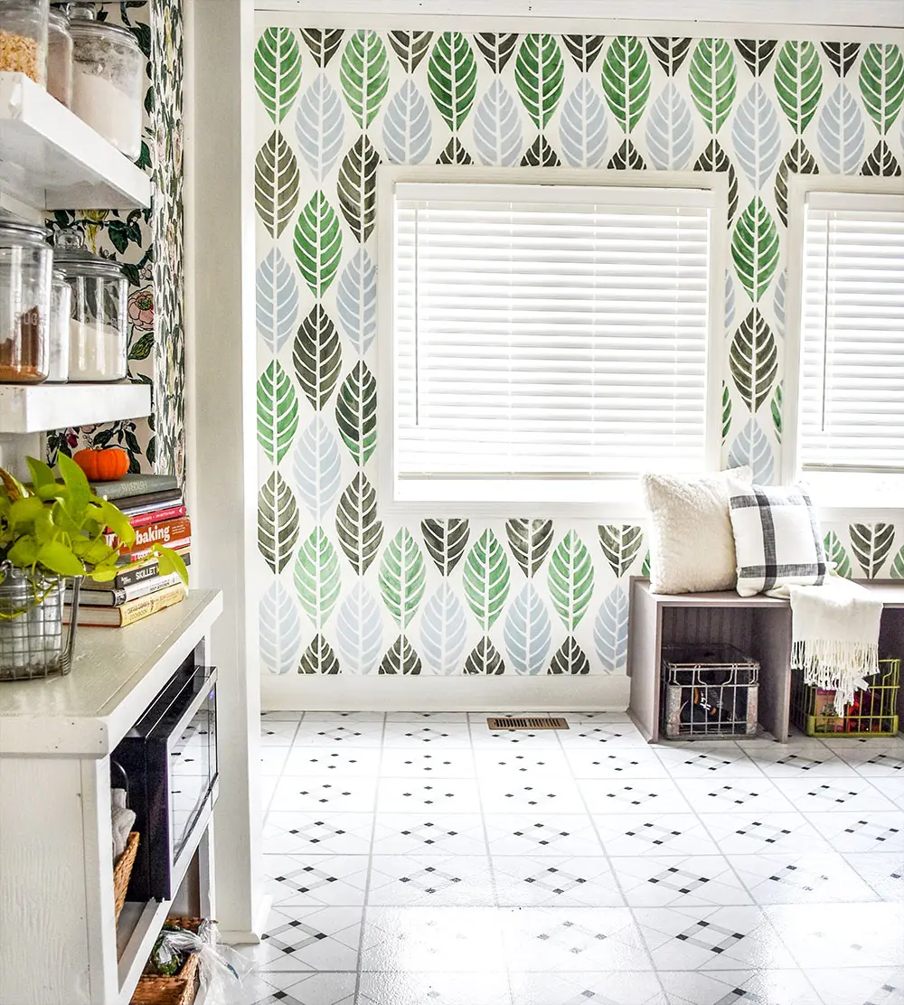 A kitchen with a beautiful peel and stick vinyl tile floor and stenciled wall