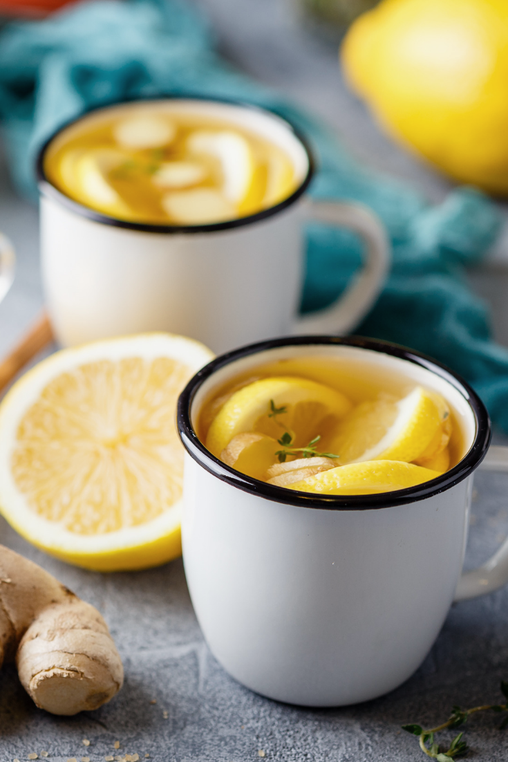 Mugs of fresh ginger root tea and lemon.