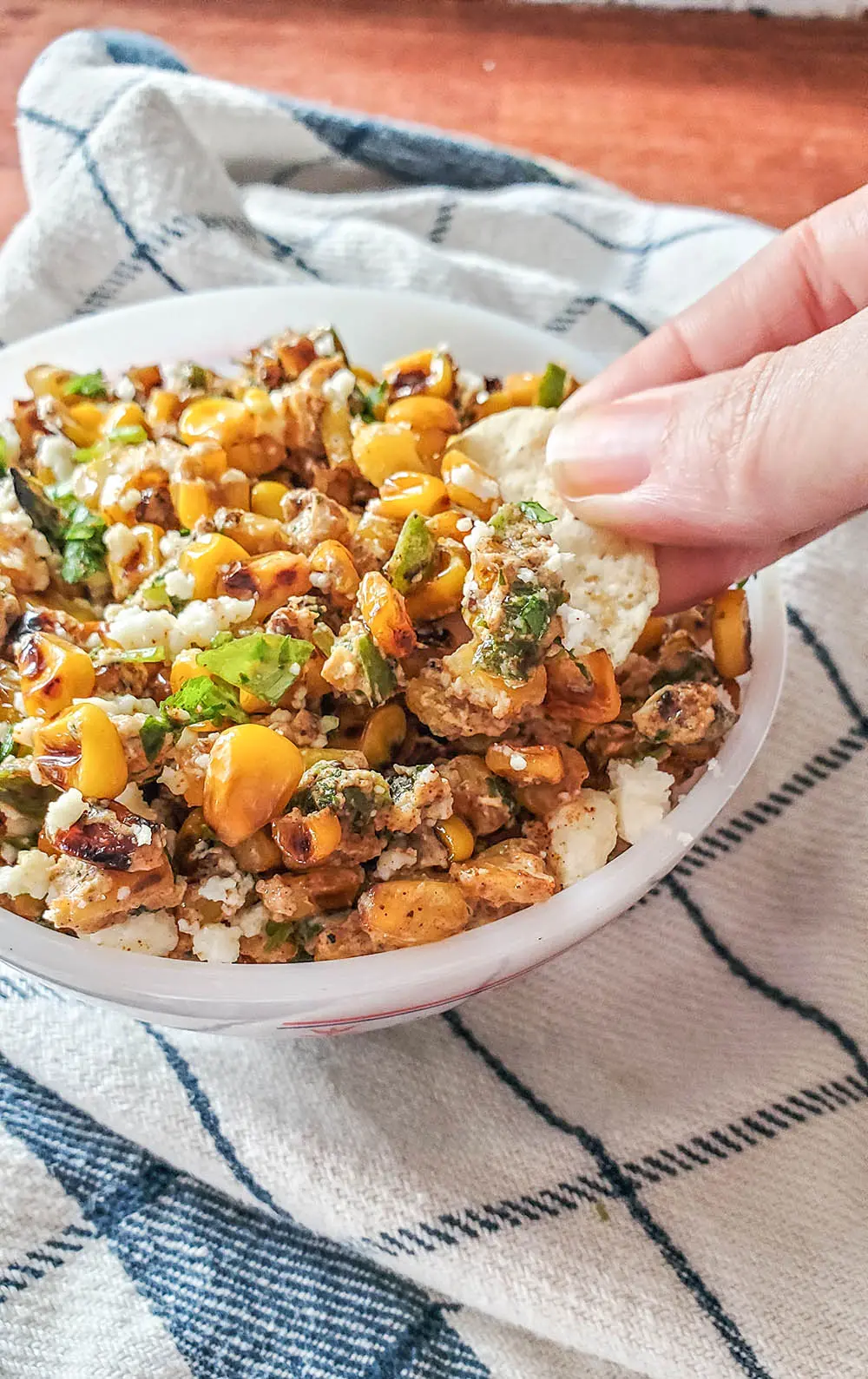 A scoop of Mexican Street Corn Dip on a tortilla chip