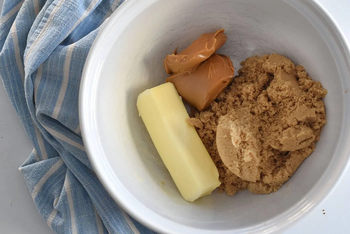 Ingredients in a bowl include butter, peanut butter, and brown sugar