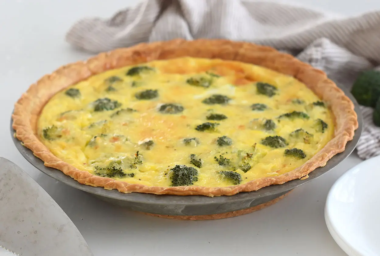 broccoli and cheese quiche in a pan on the counter.