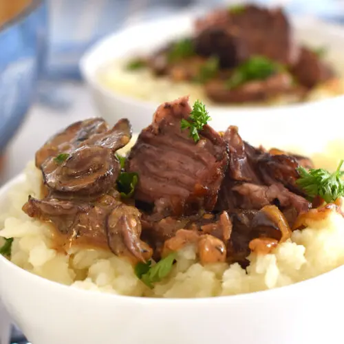 2 bowls of short ribs served over mashed potatoes