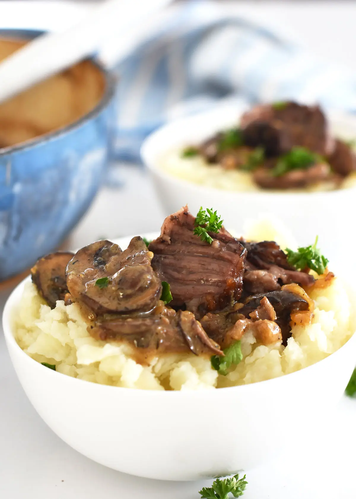 2 bowls of short ribs with mashed potatoes