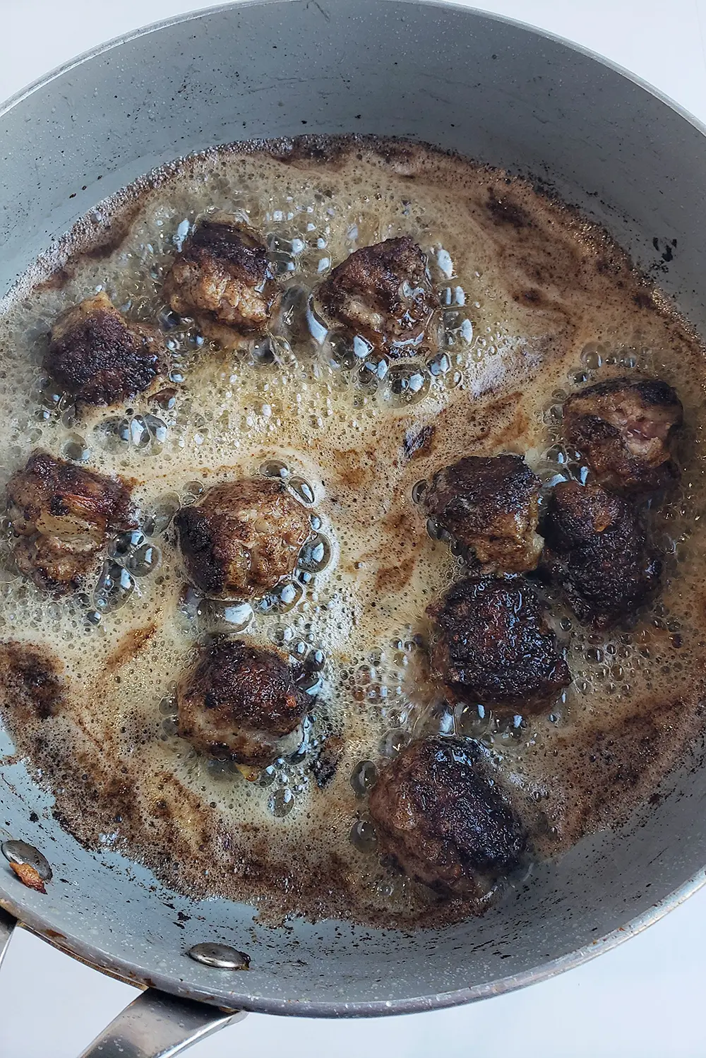 pan of swedish meatballs being fried
