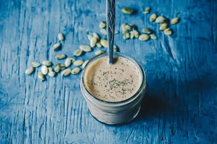 jar of dressing with pumpkin seeds on the table