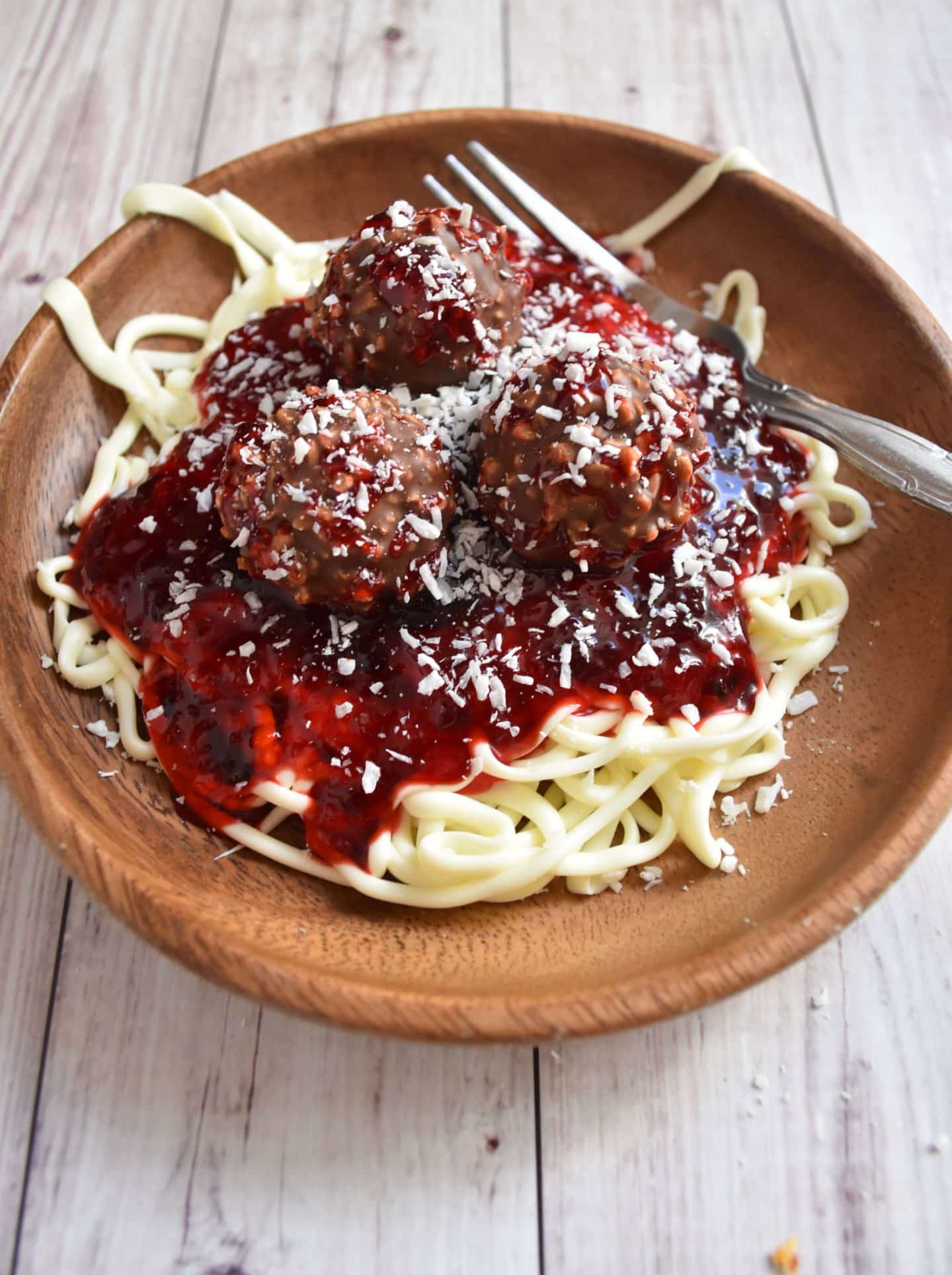 spaghetti and meatballs on a plate look just like the real thing but made with frosting, jam, and truffles. Great for April Fools Day!