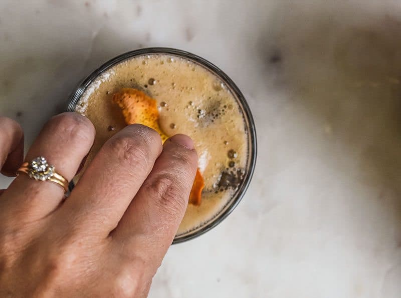 Add a bit of orange slice to the root beer cocktail.