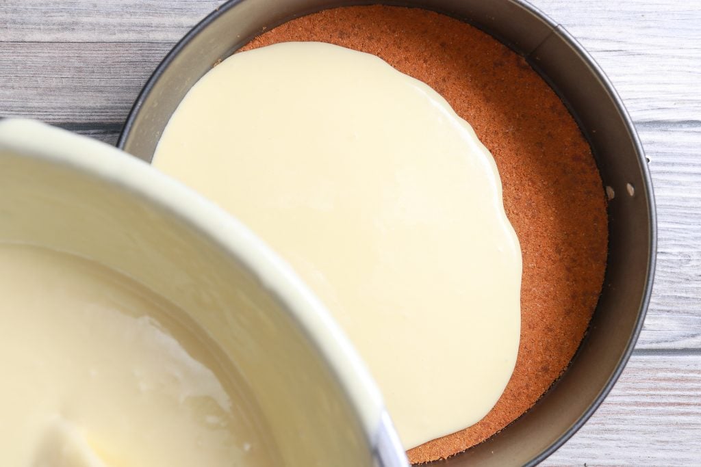 pouring the batter for the cheesecake into the pan