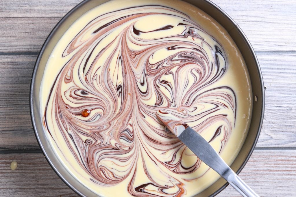 showing the swirling of hot fudge marble cheesecake