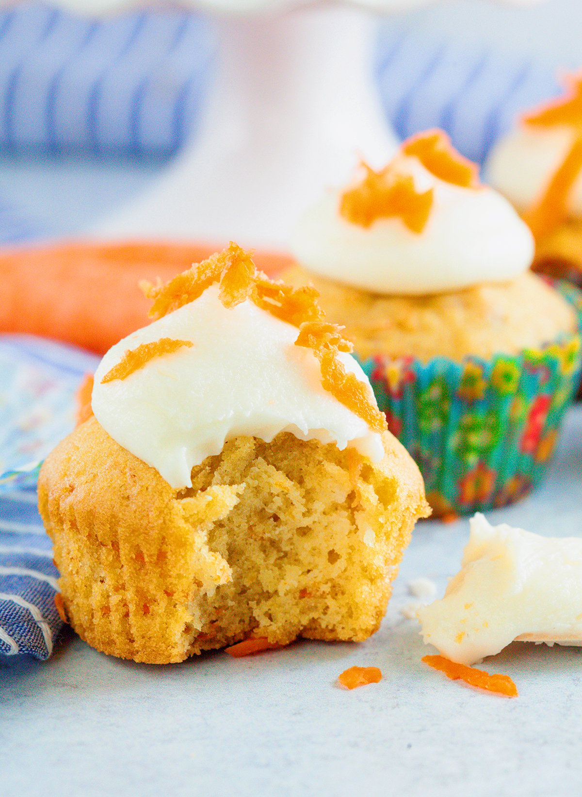 Carrot Cake cupcake with cream cheese frosting and a bit taken out.