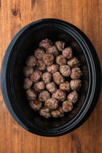 meatballs lined up in the bottom of a crock pot
