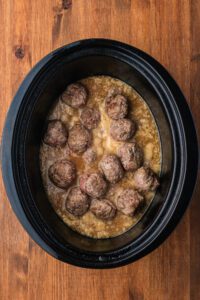 gravy mixture dumped over meatballs in crock pot
