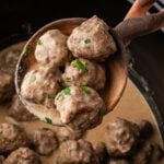 a ladle scooping swedish meatballs from the crockpot