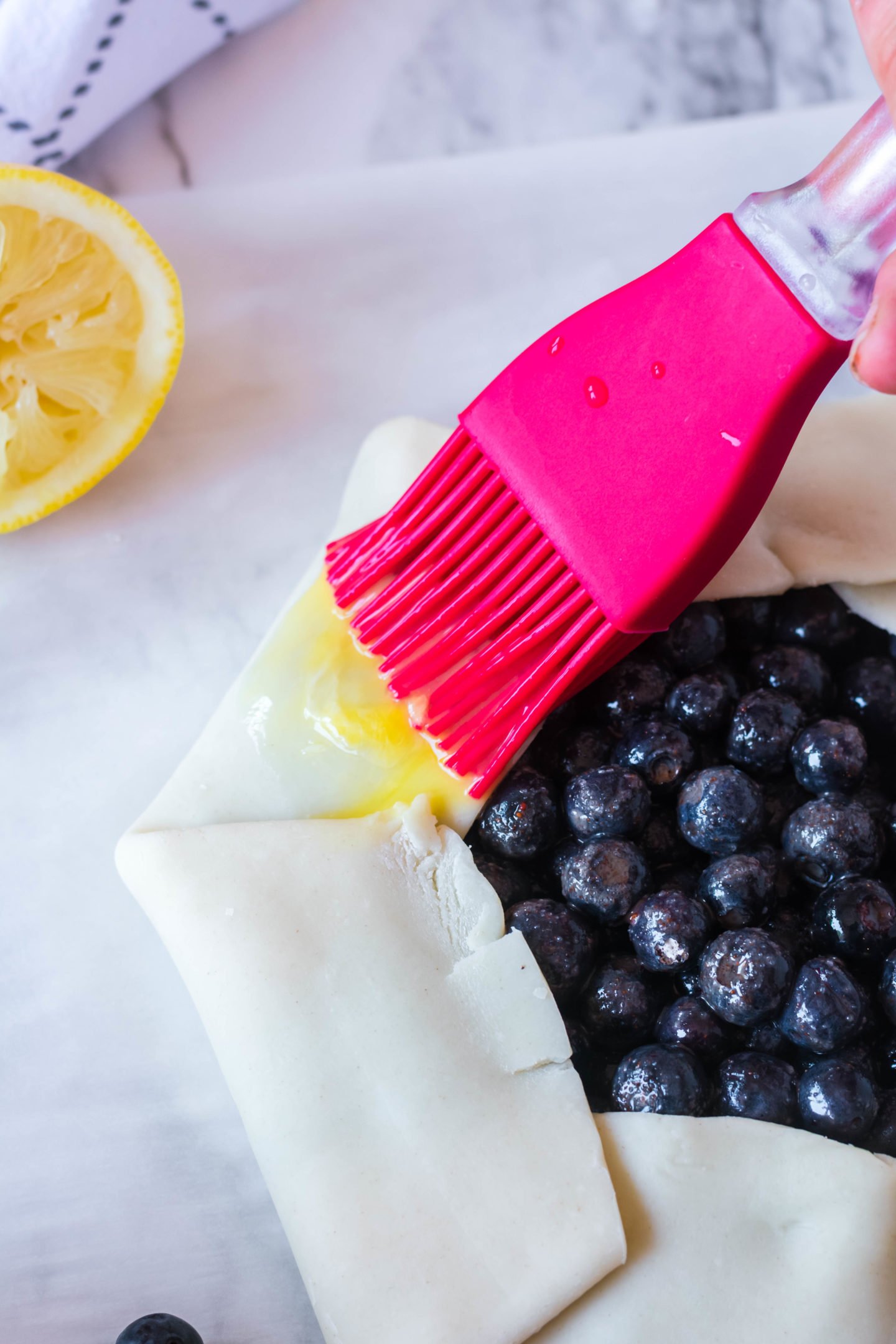 brushing the blueberry tart with egg wash