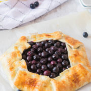 A rustic blueberry tart full of fresh berries wrapped in a pie crust.