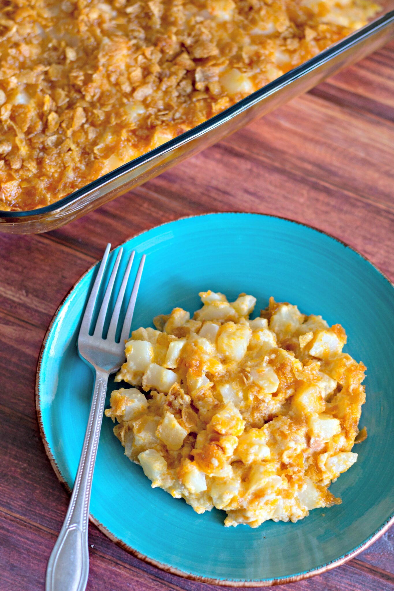 A plate of funeral potatoes with buttered cornflakes on top.