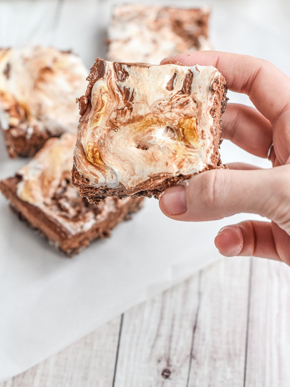 Gooey marshmallow topping on chocolate cheesecake bars