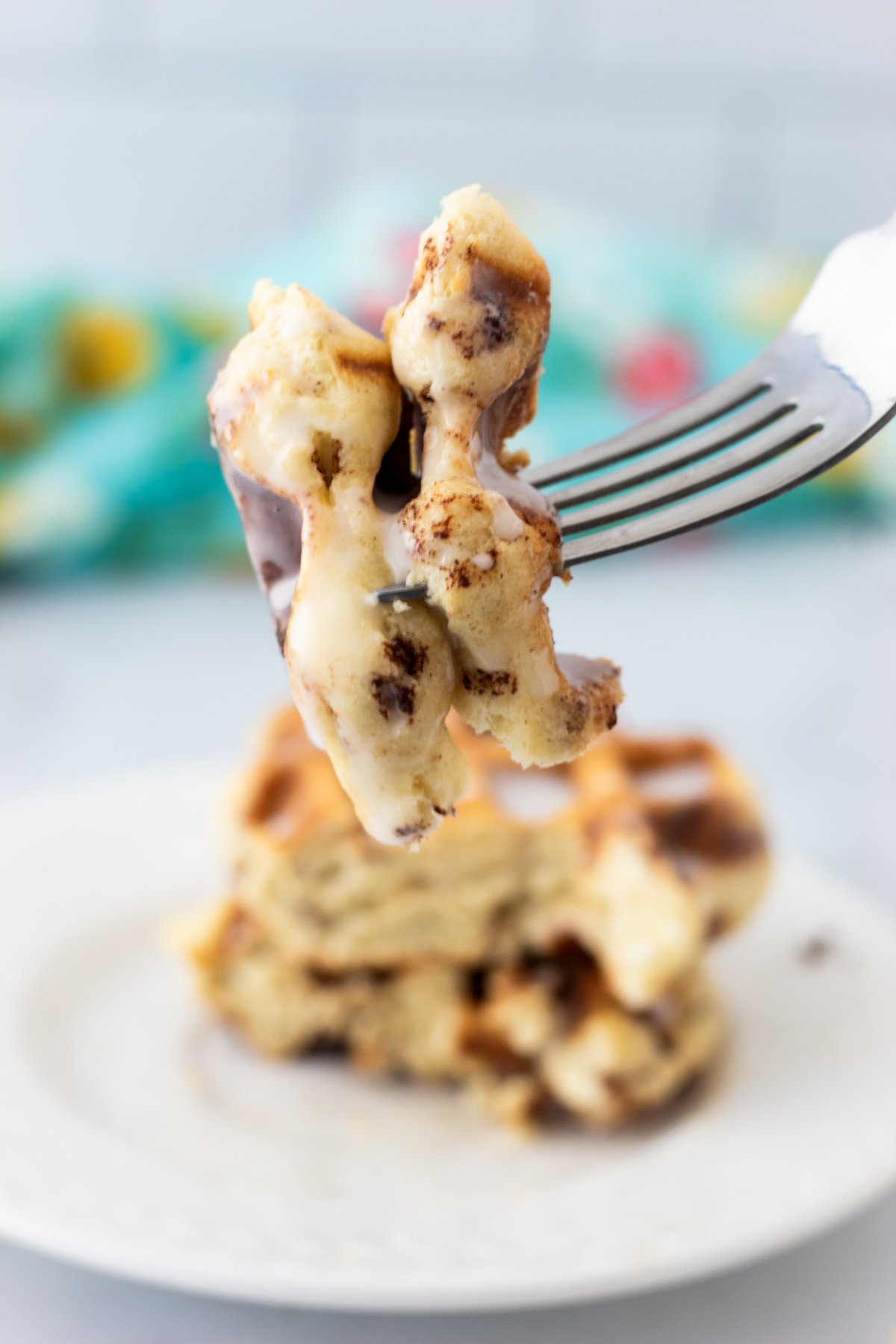 A forkful of cinnamon rolls made in the waffle maker.