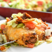 Dorito pie or casserole on a plate with a pan in the background. An easy family friendly meal!