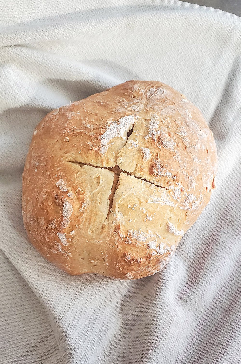 A fully baked loaf of Irish Soda bread with the X cut into the top.